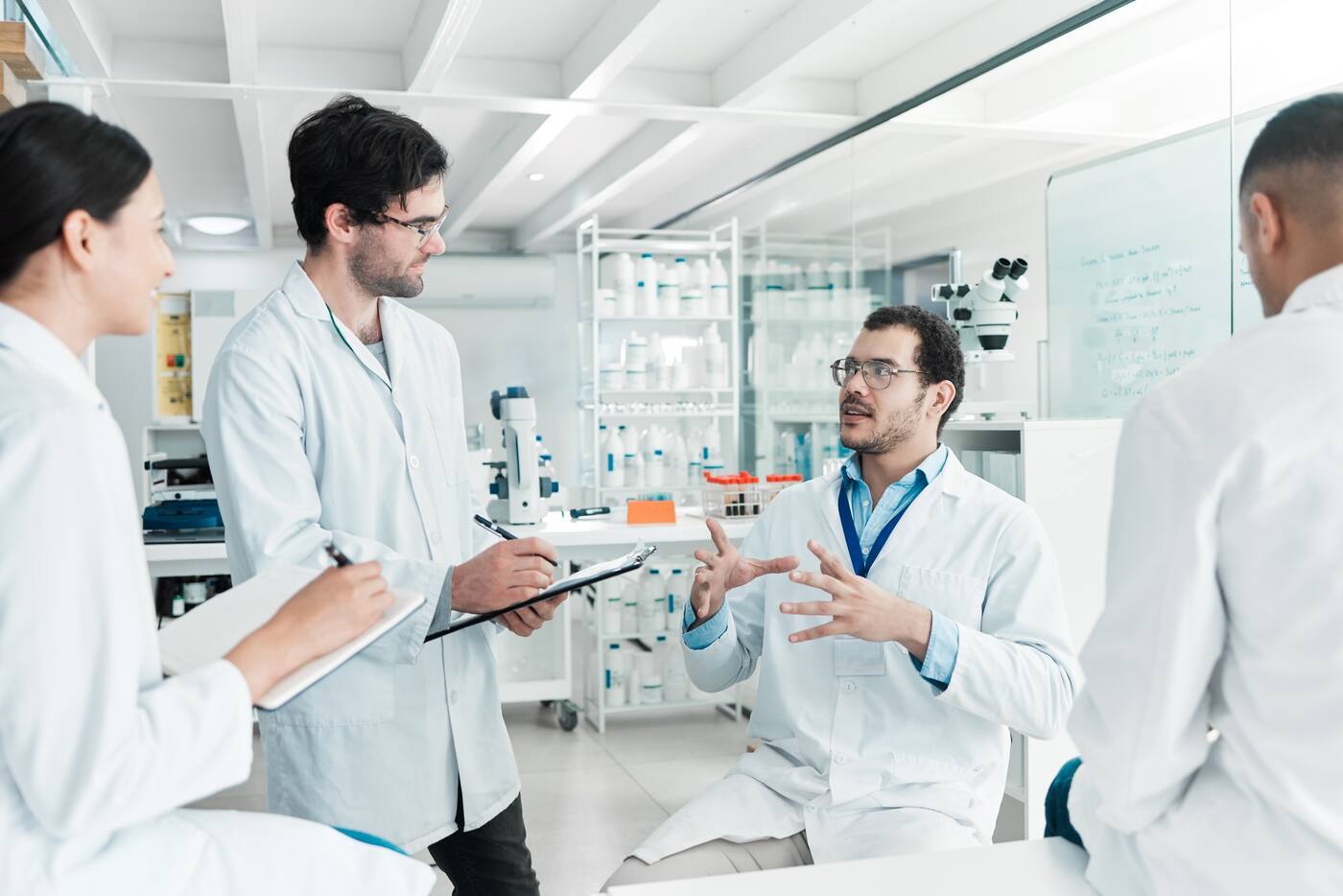 Researchers discuss results in a modern laboratory during a scientific meeting.