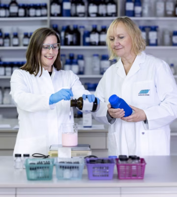 Zwei Labormitarbeiter führen in einem Analyselabor eine Qualitätskontrolle mit Proben und Laborgeräten durch.