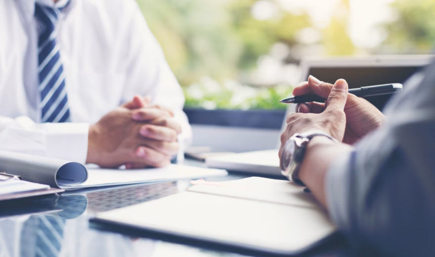 Business meeting at a conference table with documents and notes during a professional discussion.