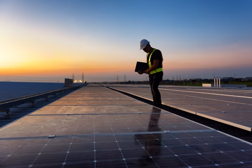 Inspectie van zonnepanelen op een zonnepark of groot dakoppervlak met behulp van een tablet voor monitoring en onderhoud.