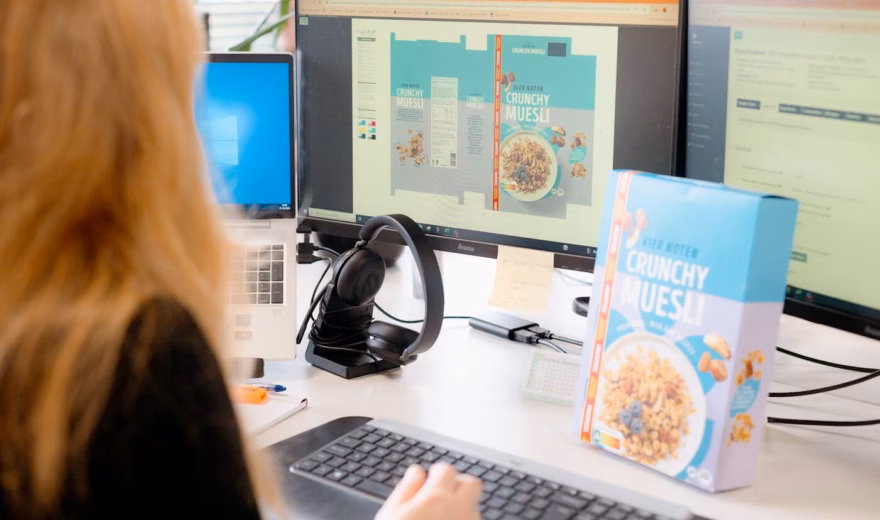 A woman is checking the label of muesli on a computer.