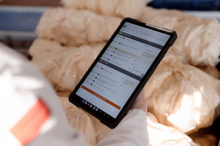 Tablet toont een digitaal formulier terwijl deze wordt gebruikt in een zorg- of thuissituatie.